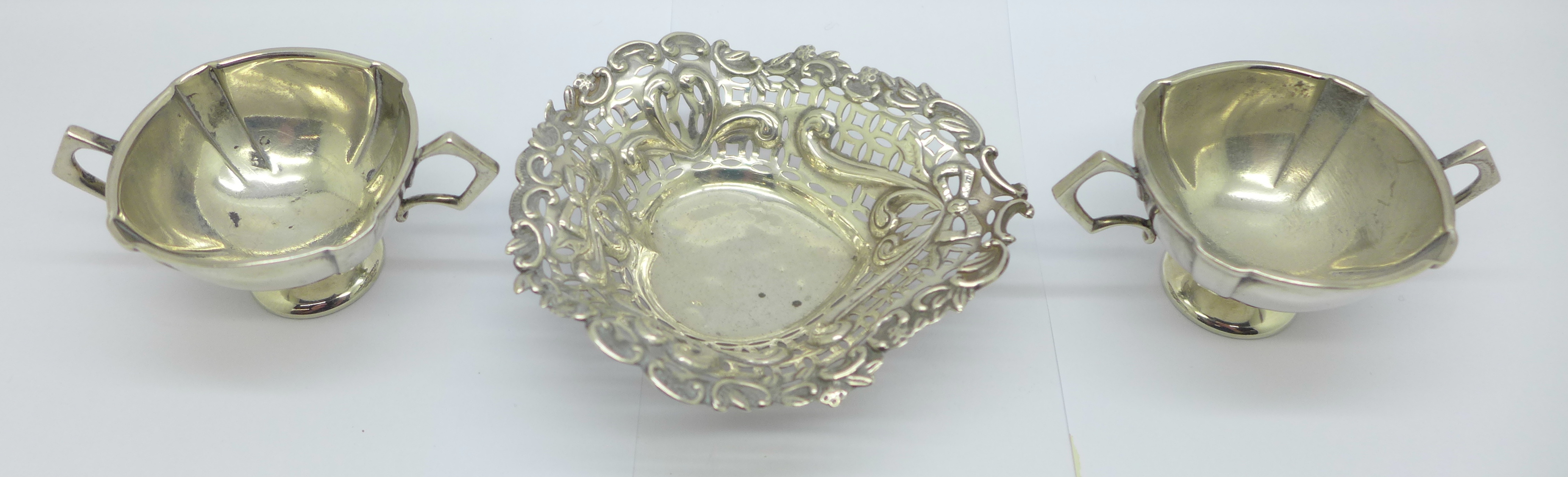 A pierced silver dish and a pair of silver salts, 73g