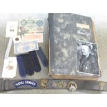 A military belt with badges affixed, German and British bank notes, a German photograph, coin, model