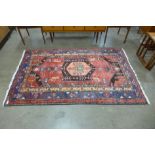 An Iranian hand knotted red ground rug, 206 x 130cms