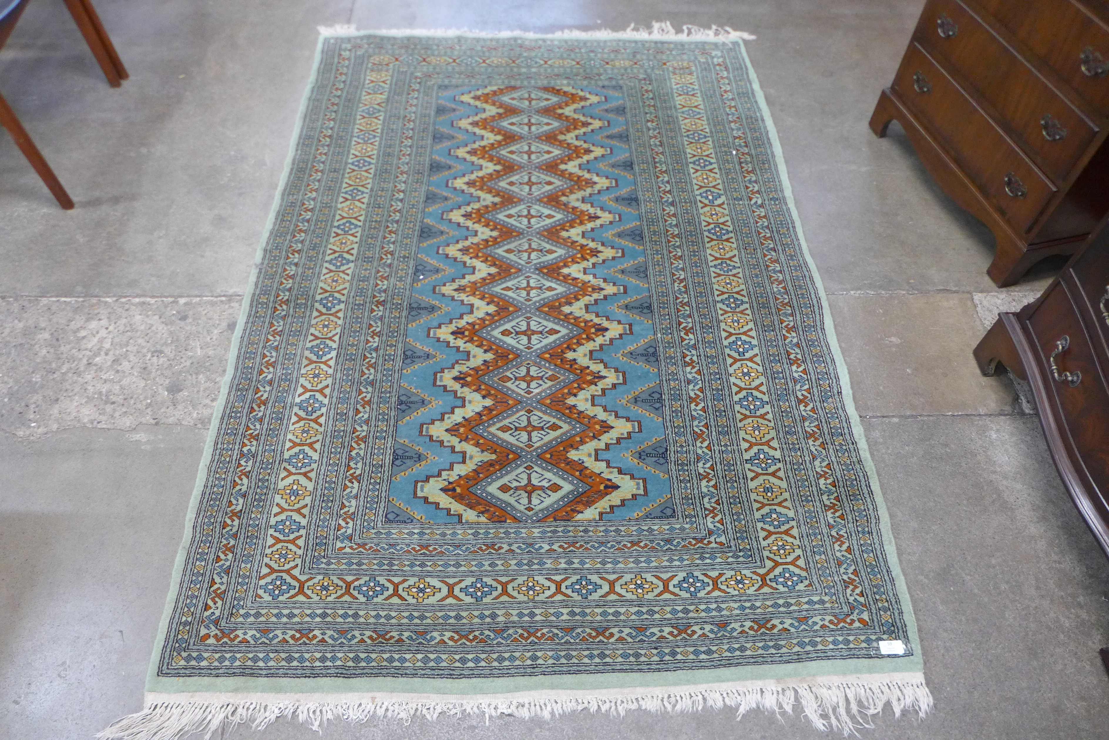 An Afghan hand knotted green ground rug, 190 x 132cms