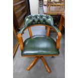 A green leather and yew wood revolving desk chair