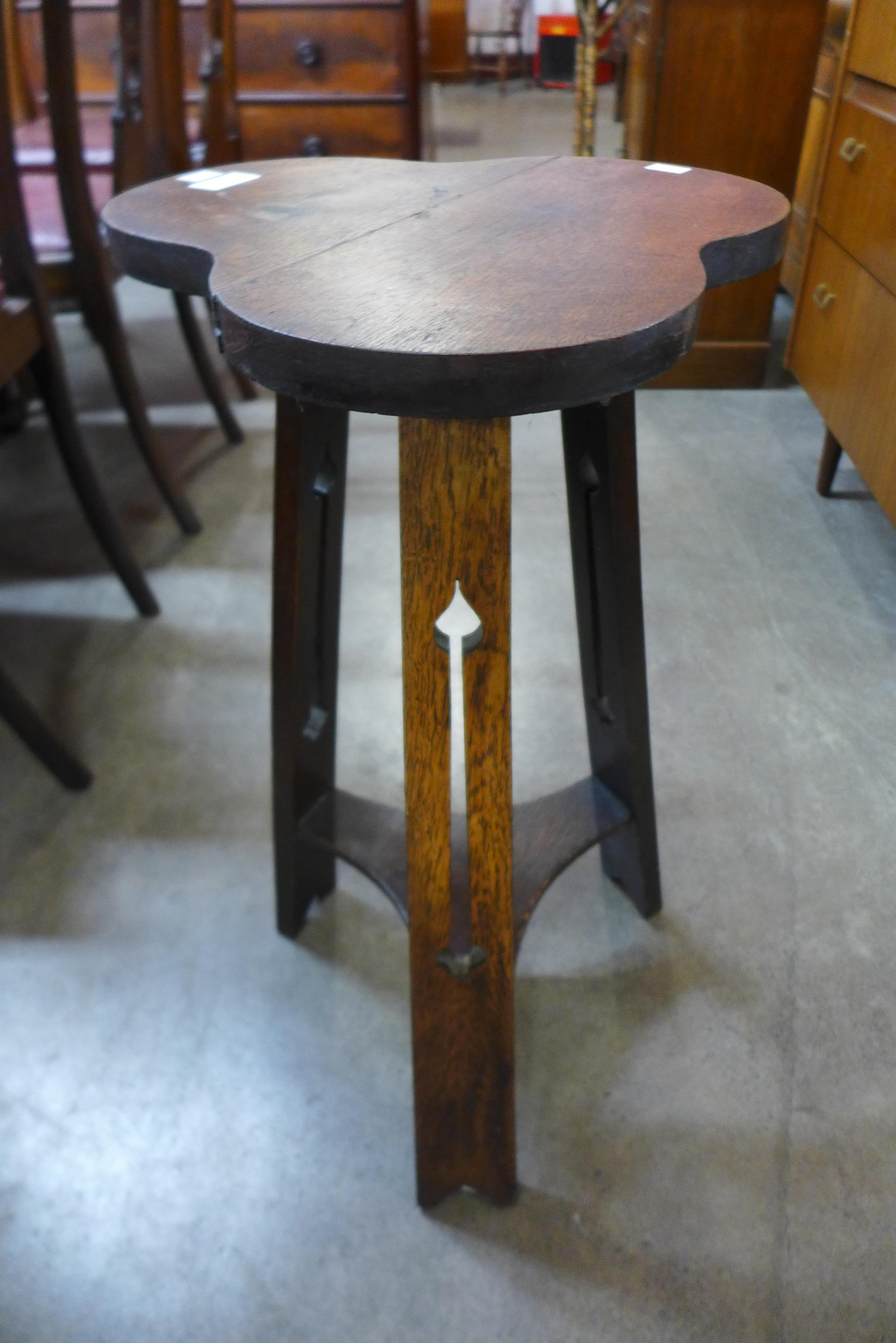 An Arts and Crafts oak trefoil top occasional table