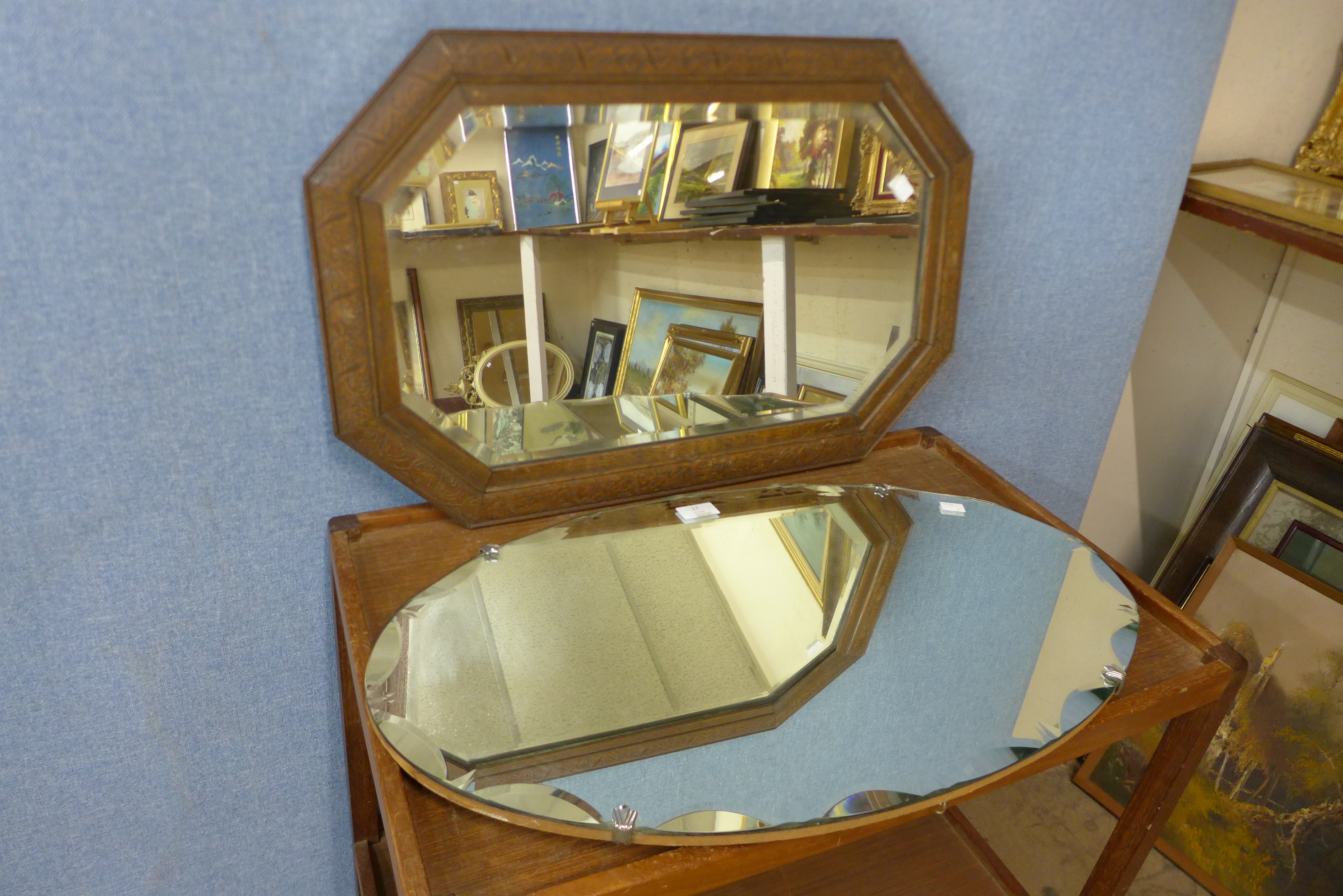 A carved oak octagonal framed mirror and another mirror