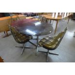 A chrome and smoked glass oval dining table and four chrome and lucite revolving chairs