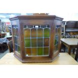 An oak and stained glass wall hanging cabinet