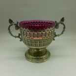 A pierced WMF two handled sugar basket with cranberry glass liner, circa 1905