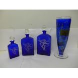 Three blue glass decanters and a Kosta Boda blue glass vase