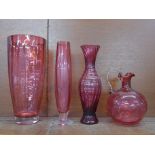 Four items of cranberry glass; large vase, 28cm, two other vases and a decanter, lacking stopper