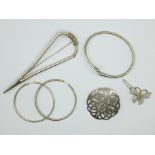 Two silver brooches, a butterfly brooch, a 925 silver bangle, and a pair of large silver hoop
