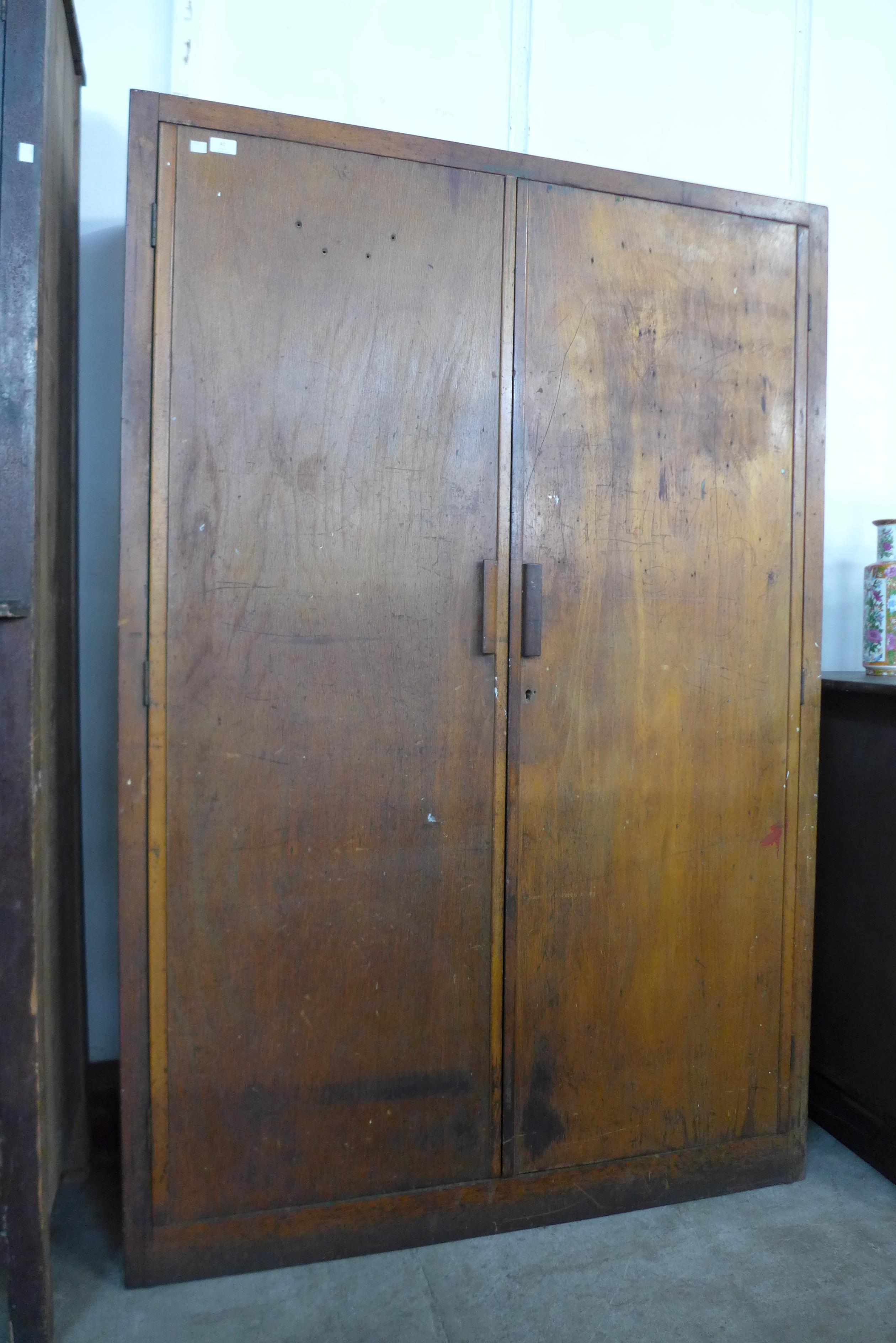 A large beech two door school cupboard