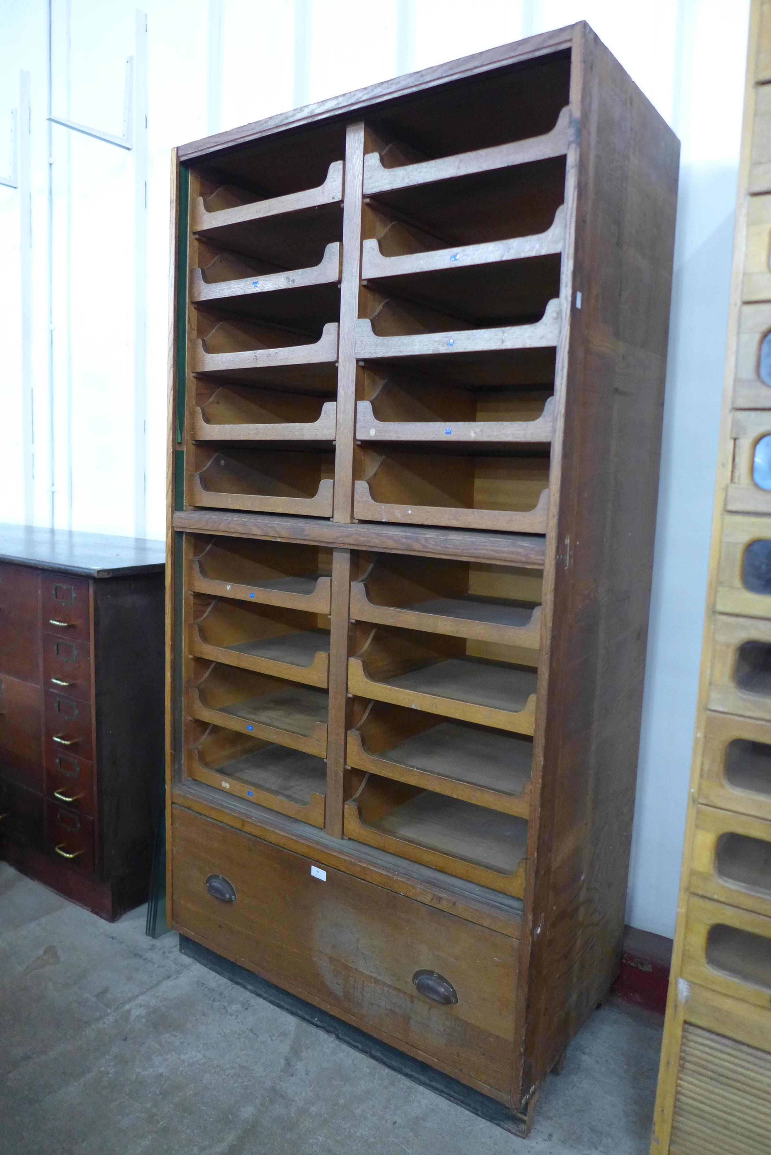 An early 20th Century oak haberdashery shop cabinet, 188cms h, 94cms w, 52cms d