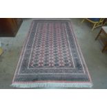 A Pakistani salmon pink ground hand knotted rug, 255 x 158cms