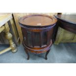 A hardwood cylindrical cabinet, with butler's tray top