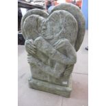 A contemporary concrete garden sculpture of lovers