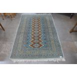 An Afghan hand knotted green ground rug, 190 x 132cms