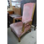 An Arts and Crafts oak and upholstered open armchair