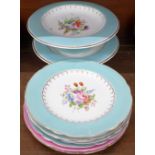 Nine plates and two cake stands decorated with hand painted flowers
