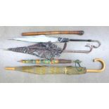 Four vintage umbrellas, three with plastic handles and a bamboo cane with oriental carving