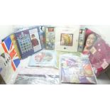 A collection of thirteen uncirculated coin packs and a set of stamps