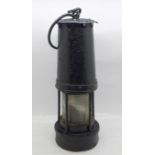 A miner's safety lamp, painted black
