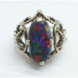 An oval cabochon cut black double opal set ring, in a white metal Arts and Crafts style setting,