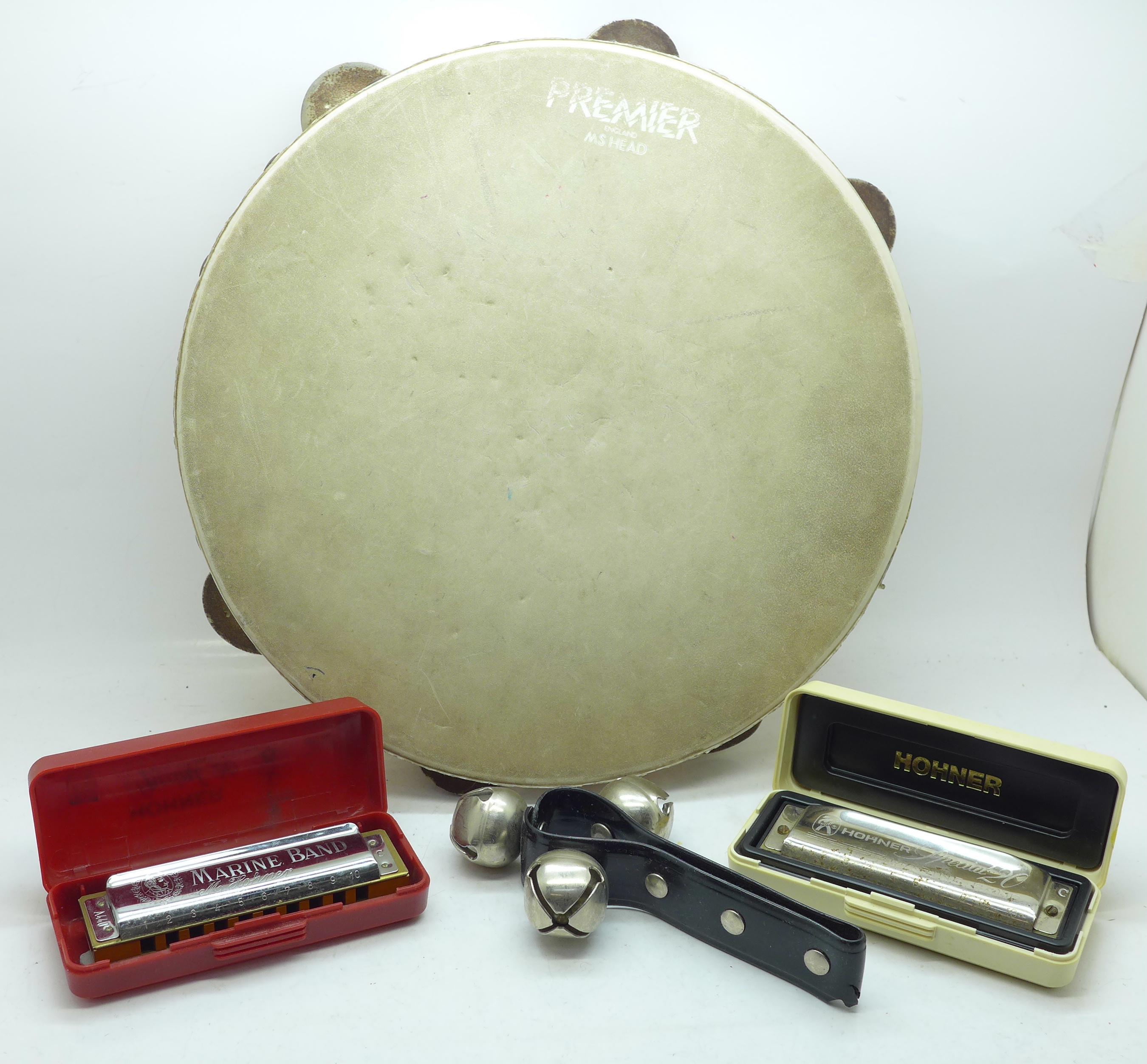 Two Hohner mouth organs, a Premier tambourine and a bell rattle