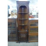 A carved oak freestanding corner cabinet