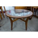 A teak and glass topped circular coffee table