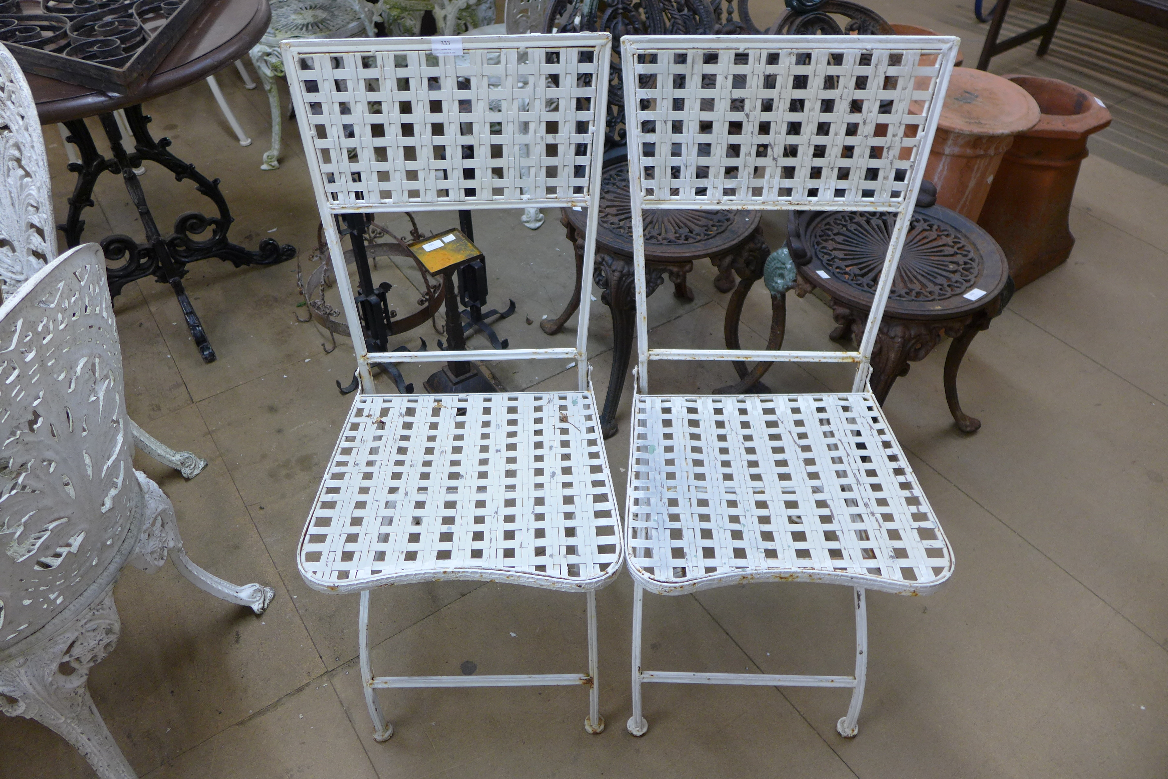A pair of painted metal folding garden chairs