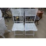 A pair of painted metal folding garden chairs
