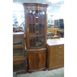 A Reprodux mahogany serpentine freestanding corner cabinet