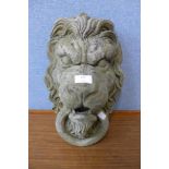 A concrete lion's head garden wall mask