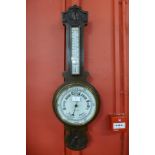 An Edward VII carved oak aneroid barometer, the ivory coloured dial signed Lancaster & Thorpe