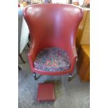 A George III style mahogany and red leather armchair and footstool