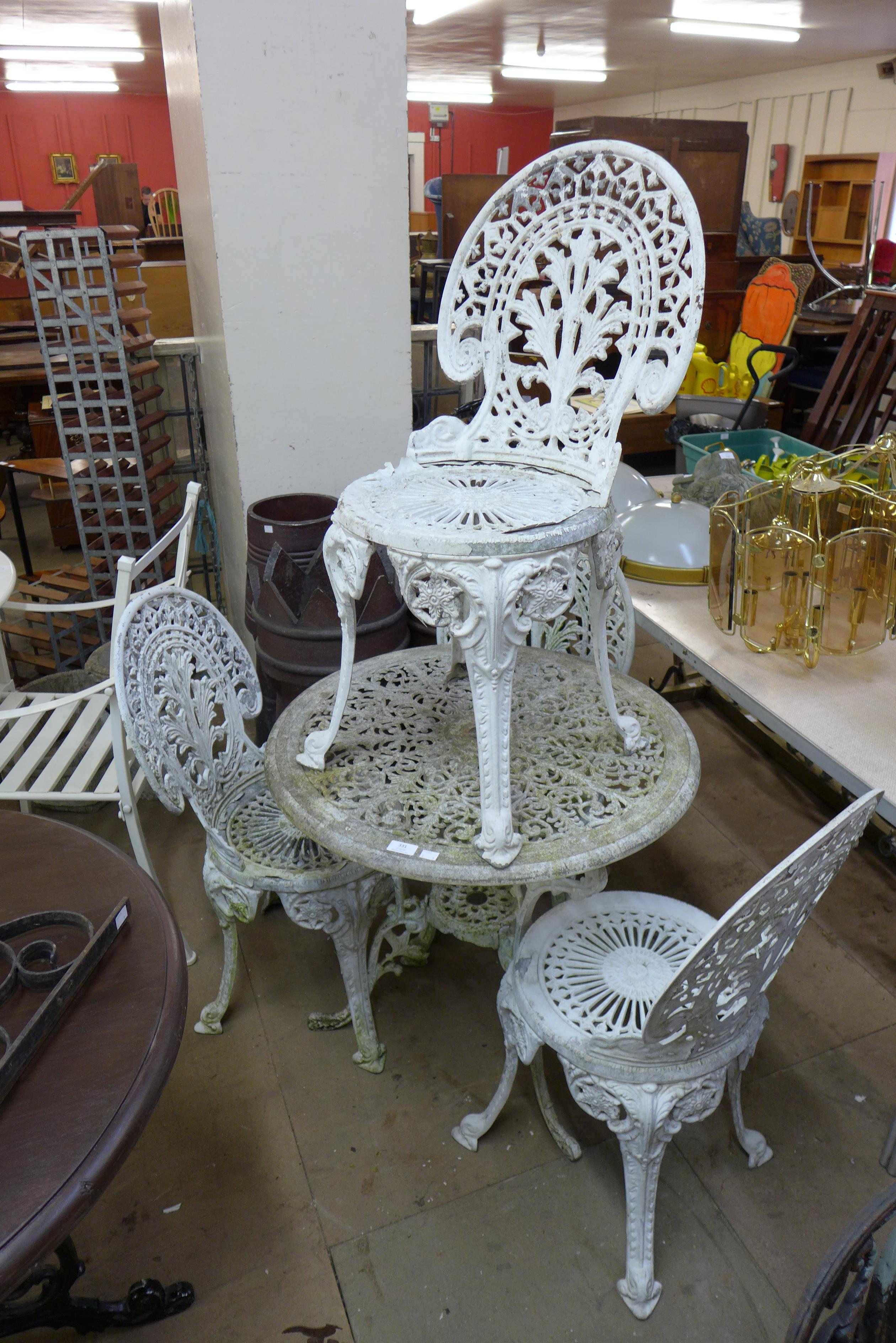 A cast alloy garden table and four chairs