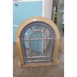An arched pine framed window