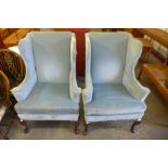 A pair of 1930's George I style mahogany and upholstered wingback armchairs