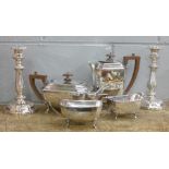 A pair of plated candlesticks and a four piece plated tea service