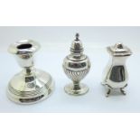 Two silver pepperettes, one marked Harrods, and a silver candlestick, pepperettes 92g