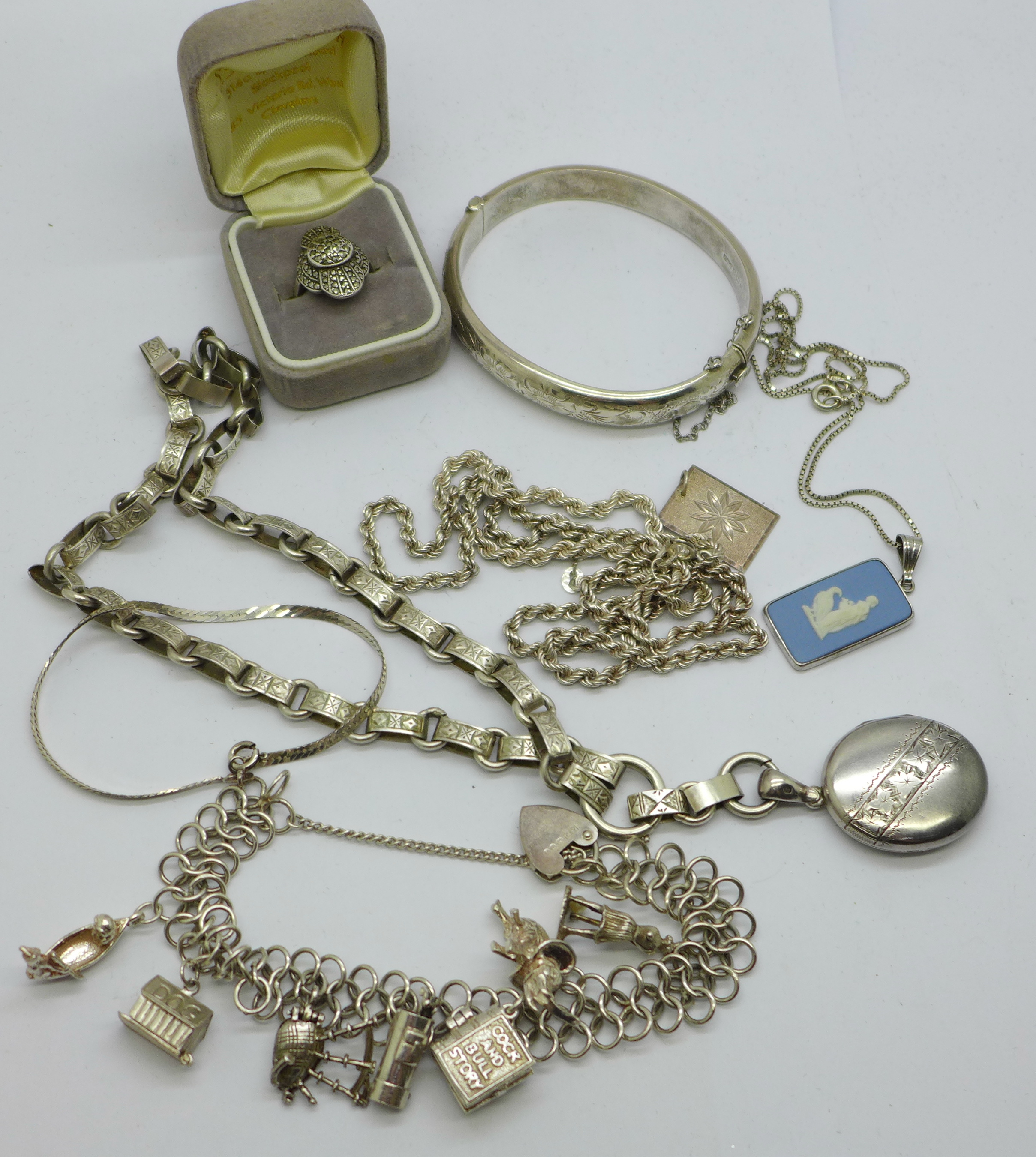 A collection of silver jewellery including a bangle, charm bracelet, locket on chain and marcasite