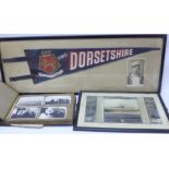 HMS Dorsetshire; a framed pennant with photograph, a framed memorial photograph with history and