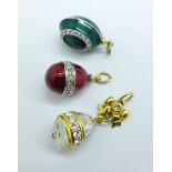 Three egg shaped charms or pendants including two enamel