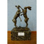 A French style bronze figure of boxing hares, on marble socle, 23cms h