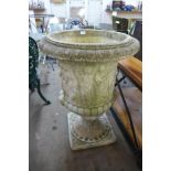 A large concrete campana shaped garden urn