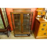 An early 20th Century oak bow front display cabinet, 121cms h, 81cms w, 49cms d