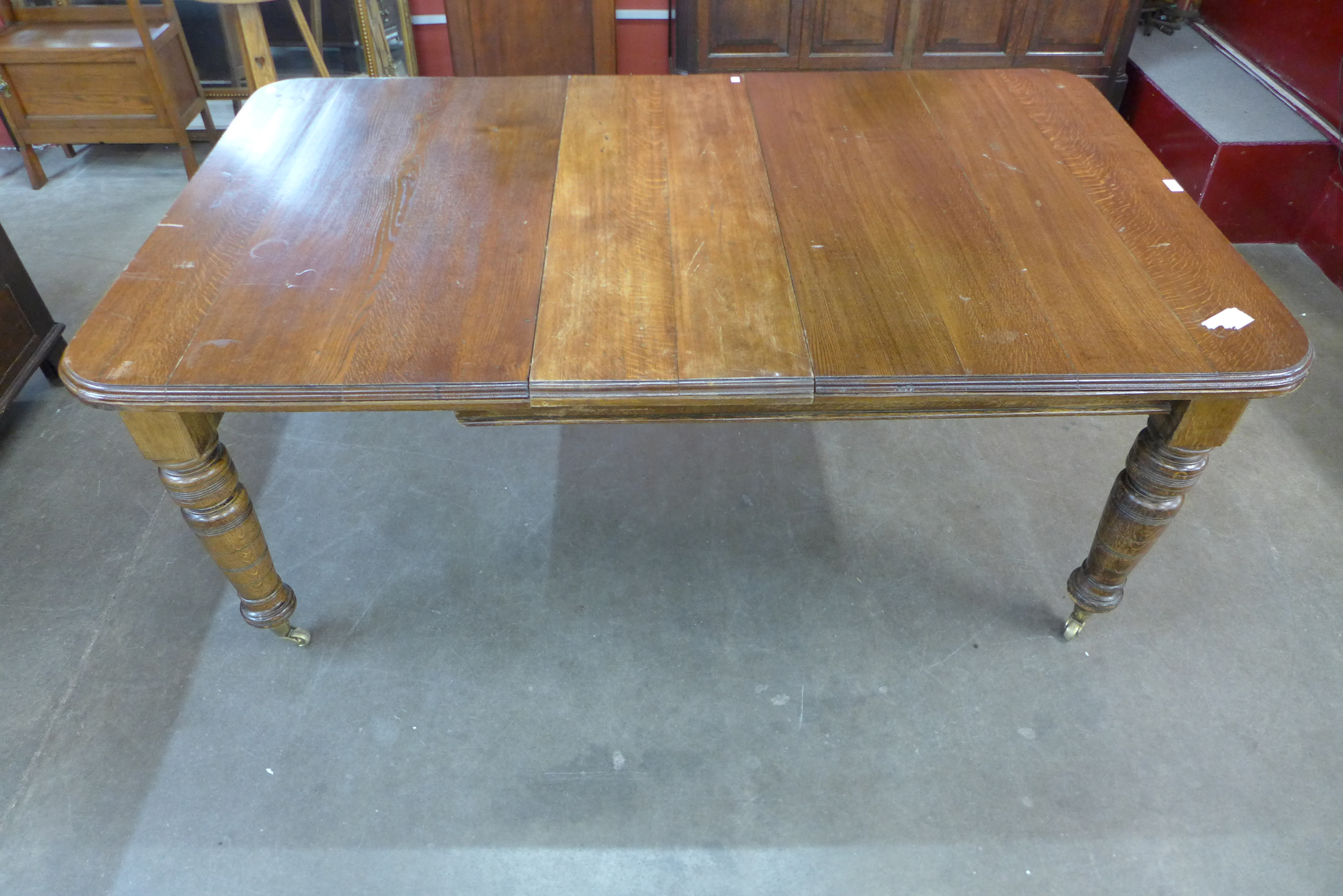 A Victorian oak extending dining table - Image 2 of 2