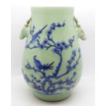 A Chinese celadon vase decorated with two birds in a Prunus bush, 21.5cm