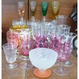 A collection of drinking glasses; five cranberry glasses, four long stemmed glasses, etched glasses,