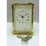 An English brass cased carriage clock with key, the dial marked Dominion