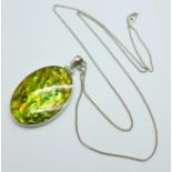 A large mother of pearl pendant with silver chain